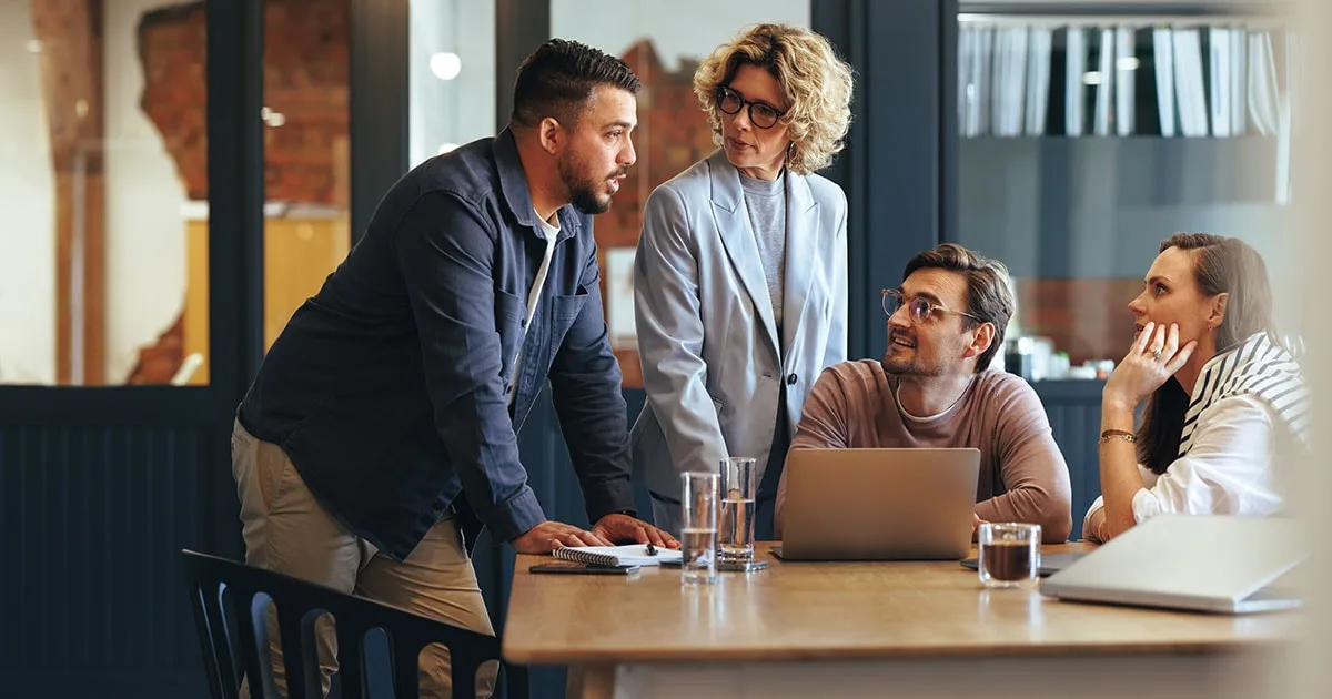 A group of marketing professionals in a modern office having a conversation.