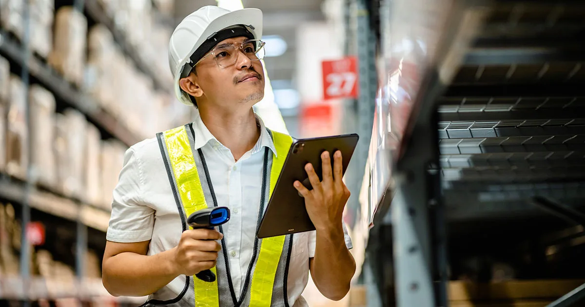 Warehouse worker checking and scanning a barcode for efficient stock inventory created as a result of effective AI Leadership and Strategy.